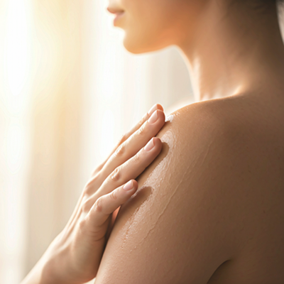 Applying natural body oil to damp skin using long sweeping strokes